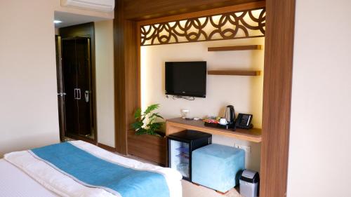 a bedroom with a bed and a tv on a wall at Hotel Labella Bergama in Bergama