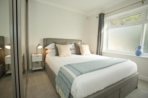 um quarto com uma cama grande e uma janela em Chine Wood Retreat - Walk to the beach and the lovely Westbourne - Free parking em Bournemouth
