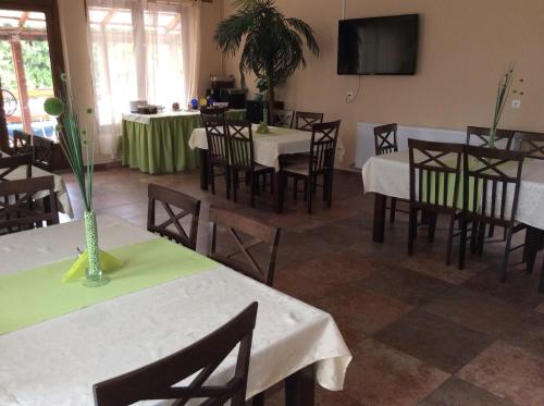 a dining room with tables and chairs and a tv at Abszolút Hotel és Panzió in Nyírbátor