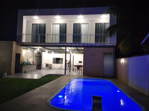 una casa con una piscina azul frente a una casa en espaço 16, en Maricá