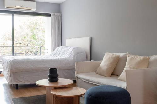 uma sala de estar com uma cama e um sofá em Acacia Beautiful Studio em Buenos Aires