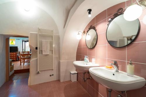 a bathroom with two sinks and a mirror at Corte Regina in Sogliano Cavour