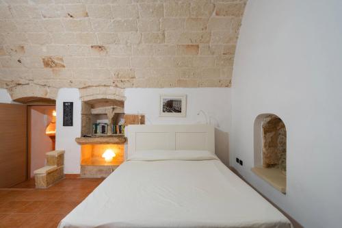 a bed in a room with a stone wall at Corte Regina in Sogliano Cavour