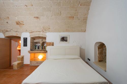 Bett in einem Zimmer mit einer Steinmauer in der Unterkunft Corte Regina in Sogliano Cavour