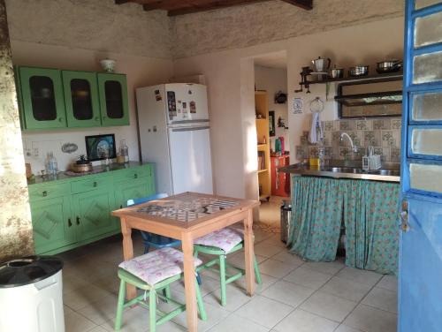 uma cozinha com armários verdes e uma mesa de madeira em Hostel Casa do Bolaxa em Rio Grande