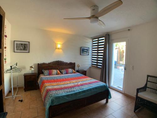 a bedroom with a bed and a ceiling fan at Villa La Rose des Vents in Tourrettes