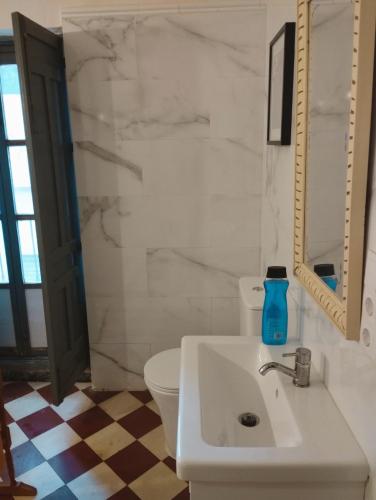 a bathroom with a white sink and a toilet at Caserón Centenario in Cehegín