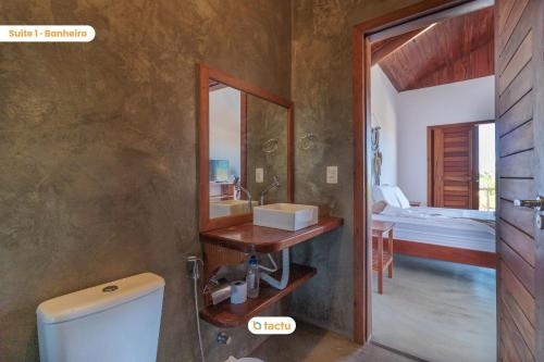 La salle de bains est pourvue d'un lavabo, de toilettes et d'un miroir. dans l'établissement Apto térreo no Pontal do Maceió Tactu, à Maceió