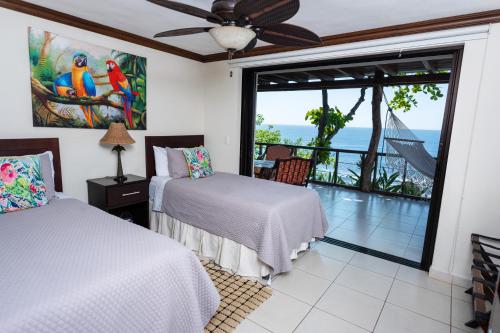 a bedroom with two beds and a view of the ocean at Paraiso Escondido Hotel Villas & Resort in El Níspero