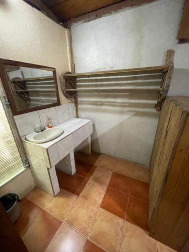 een badkamer met een wastafel en een spiegel bij Hotel Ecológico Cabañas del Lago in El Estor