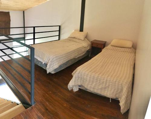 two twin beds in a room with a staircase at LOFT JUJUY, Alto Gorritti - Departamento cerca del Centro in San Salvador de Jujuy