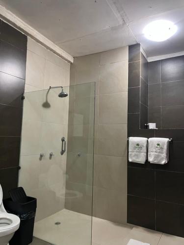 a bathroom with a glass shower with a toilet at Samai Lodge Holistic Living in Olón