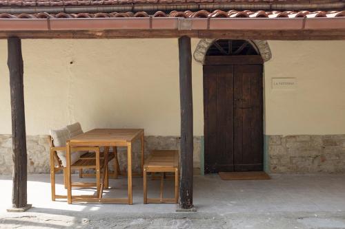 einen Holztisch, zwei Stühle und eine Tür in der Unterkunft Agriturismo Ca' Pasquin in Roccaverano