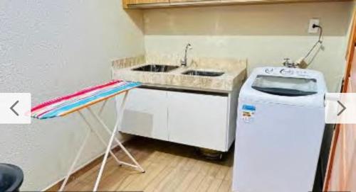 a kitchen with a sink and a washing machine at Casa Parque Minas in Córguinho