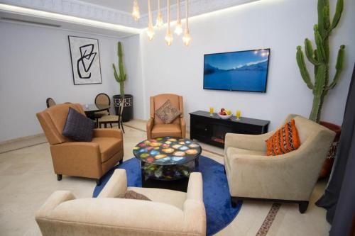 a living room with couches and a tv on the wall at Luxe apartment / Prime location / 2 bedr- 2.5 bathrooms in Marrakech