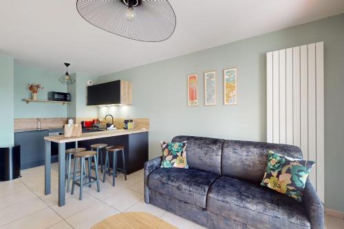 un salon avec un canapé et une cuisine dans l'établissement L'Equateur - 4 people garage near lake, à Annecy