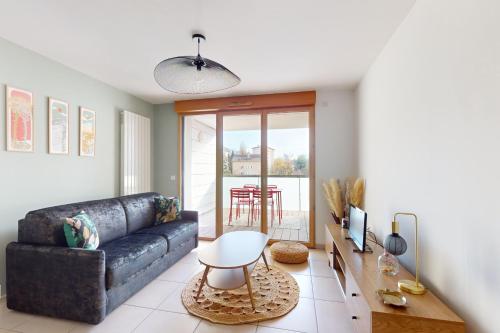 un salon avec un canapé et une table dans l'établissement L'Equateur - 4 people garage near lake, à Annecy