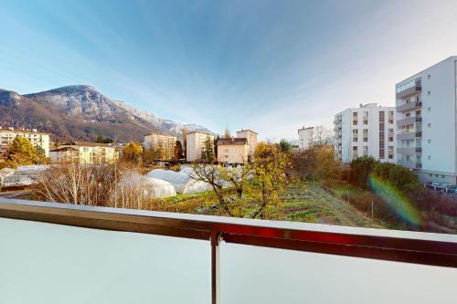 uma vista para uma cidade com edifícios e montanhas em L'Equateur - 4 people garage near lake em Annecy