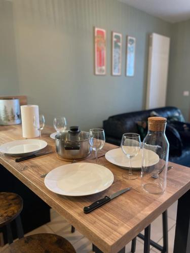 une table en bois avec des assiettes et des verres à vin dessus dans l'établissement L'Equateur - 4 people garage near lake, à Annecy