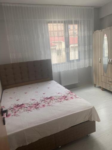 a bedroom with a bed with pink flowers on it at 1+1 in Hopa