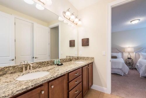 een badkamer met 2 wastafels en een grote spiegel bij EC464 - Incredible Villa with Themed Games Room at Encore in Orlando
