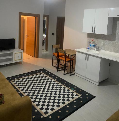 a kitchen and living room with a checkered rug at 1+1 in Hopa
