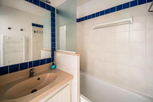 une salle de bain avec une baignoire, un lavabo et un miroir dans l'établissement Résidence Bleu Marine - maeva Home - Appartement 2 pièces 4 personnes Confort MAE-7359, à Lacanau