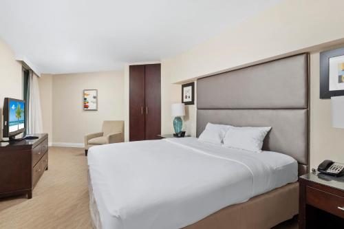 a hotel room with a large bed and a television at GALLERY One - A DoubleTree Suites by Hilton Hotel in Fort Lauderdale