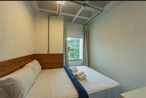 een slaapkamer met een bed met twee handdoeken erop bij Apartamento com garagem no Centro de Guaramiranga in Guaramiranga