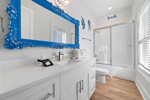 uma casa de banho com um espelho azul e um lavatório branco em Sea At Last em Gulf Shores