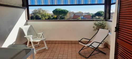 2 stoelen op een balkon met een groot raam bij Appartamento Bellaria-Igea Marina con terrazza in Bellaria-Igea Marina