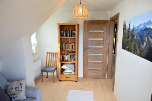 een woonkamer met een boekenplank en een deur bij Chatka Beatki in Stryszawa
