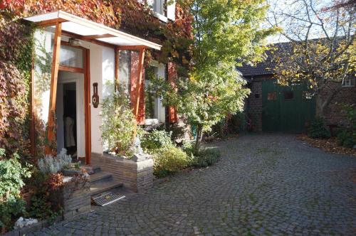 una casa con un vialetto di mattoni accanto a un garage di Hof am Rhein a Colonia