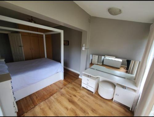 a bedroom with a white bed and a mirror at 1211 On Bluff in Durban