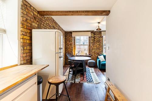 cocina y comedor con pared de ladrillo en Charming Shoreditch Apartment, en Londres