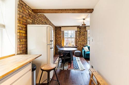 a kitchen and dining room with a brick wall at Charming Shoreditch Apartment in London