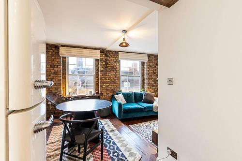 ein Wohnzimmer mit einem Tisch und einem Sofa in der Unterkunft Charming Shoreditch Apartment in London