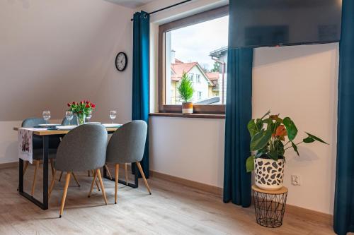 a dining room with a table and chairs and a window at Apartamenty Wisła Krzywa 8, wanna z hydromasażem, basen zewnętrzny in Wisła