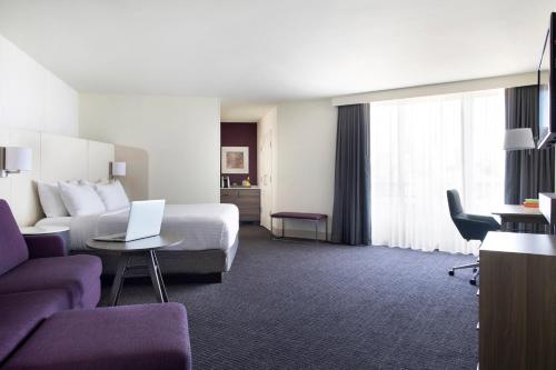 a hotel room with a bed and a laptop on a table at Crowne Plaza Atlanta Perimeter at Ravinia by IHG in Atlanta