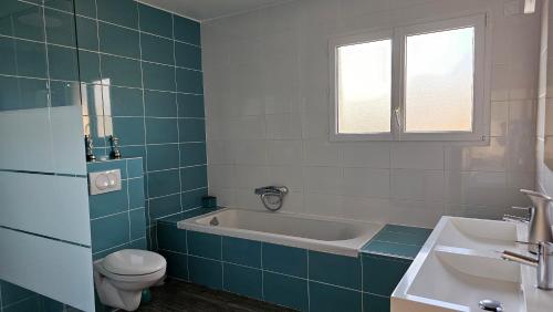 ein Badezimmer mit einer Badewanne, einem WC und einem Waschbecken in der Unterkunft Morena Villa Familiale in Bompas