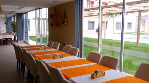 a row of tables and chairs in a room with windows at Hotel Labella Bergama in Bergama