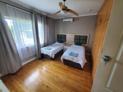 a small bedroom with two beds and a window at 1211 On Bluff in Durban