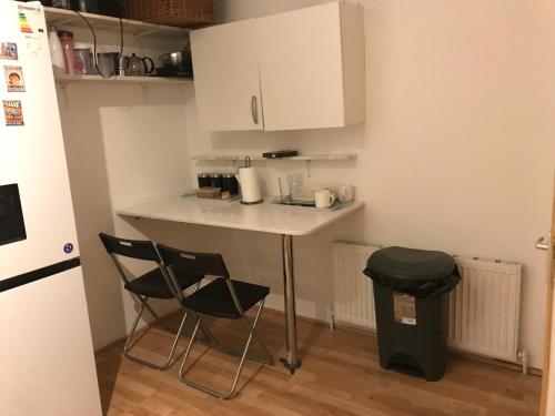 una pequeña cocina con 2 sillas y una barra en Spacious Large Modern Double close to Central London Breakfast Included en Londres