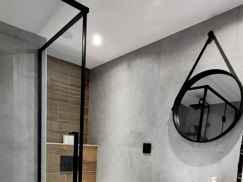 a mirror hanging on a wall in a bathroom at Mieszkanie przy rzece in Gołdap