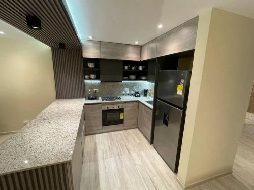 una cocina con electrodomésticos de acero inoxidable y armarios de madera en Casa Martha, en Cartagena de Indias