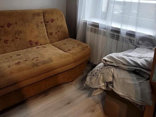 a couch sitting in a room with a window at Mieszkanie przy rzece in Gołdap
