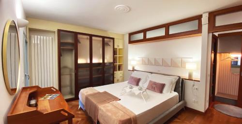 a bedroom with a large white bed and a desk at FWL The Lake Suite in Arona