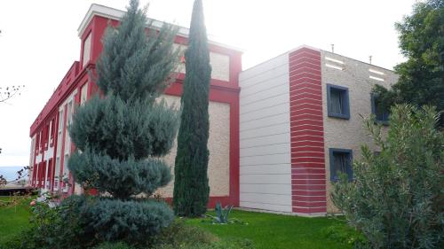 a red and white building with a tree next to it at Hotel Labella Bergama in Bergama