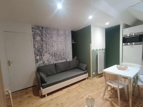 een woonkamer met een bank en een tafel bij Studio centre Cauterets in Cauterets