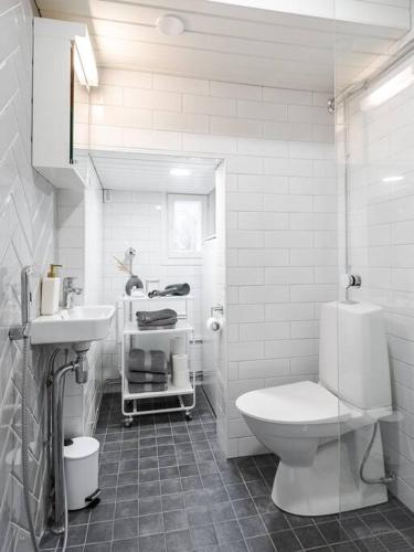 a white bathroom with a toilet and a sink at Lakeview retreat in Pispala in Tampere